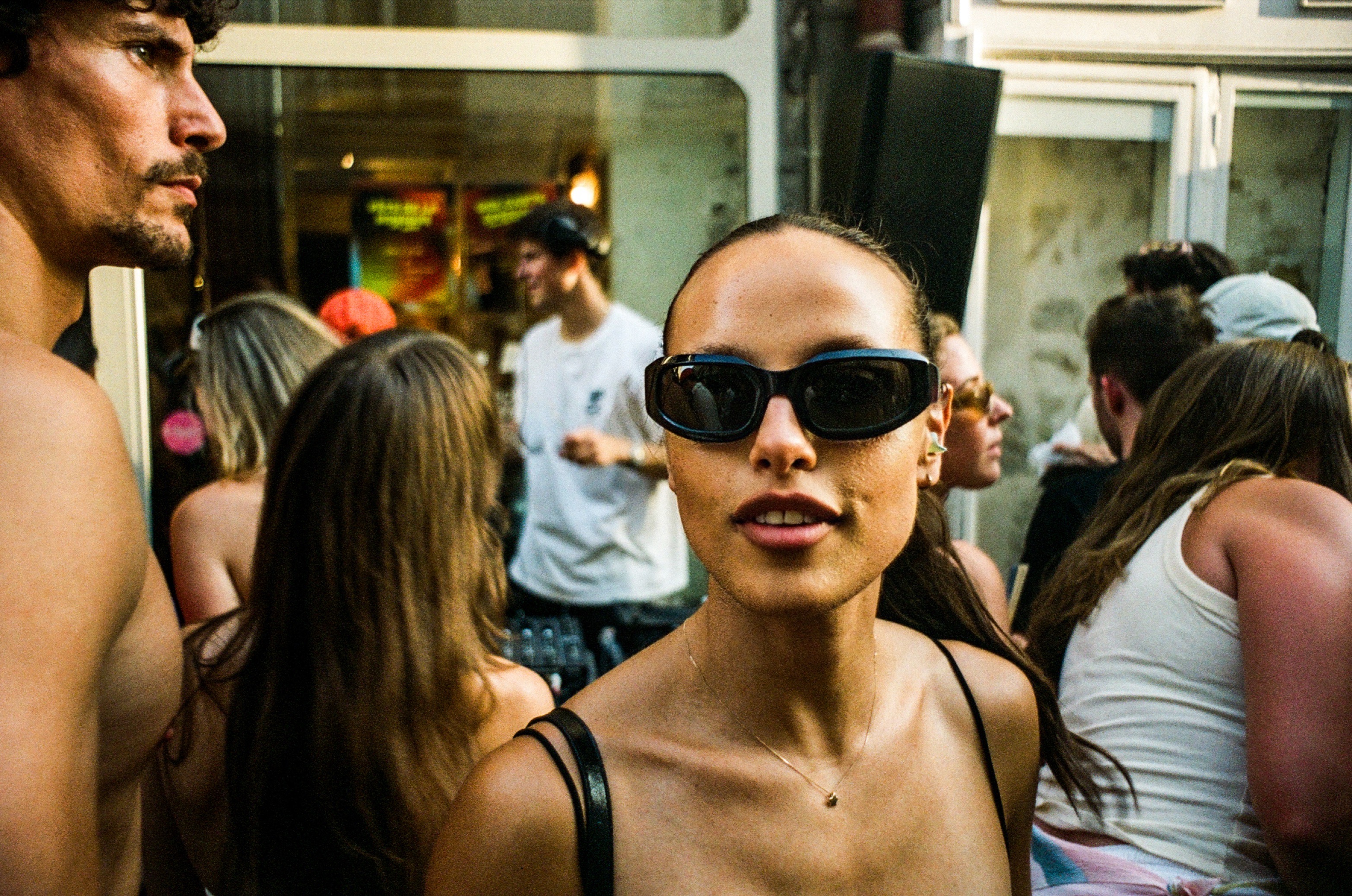 Woman in sunglasses looking into the camera in a crowd