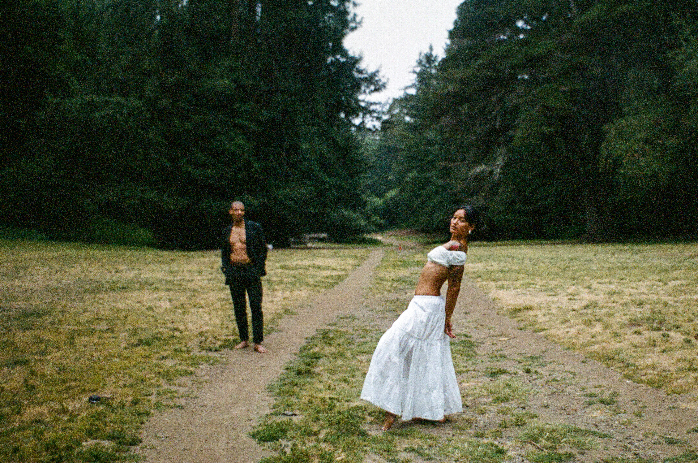 Two people standing apart in a field