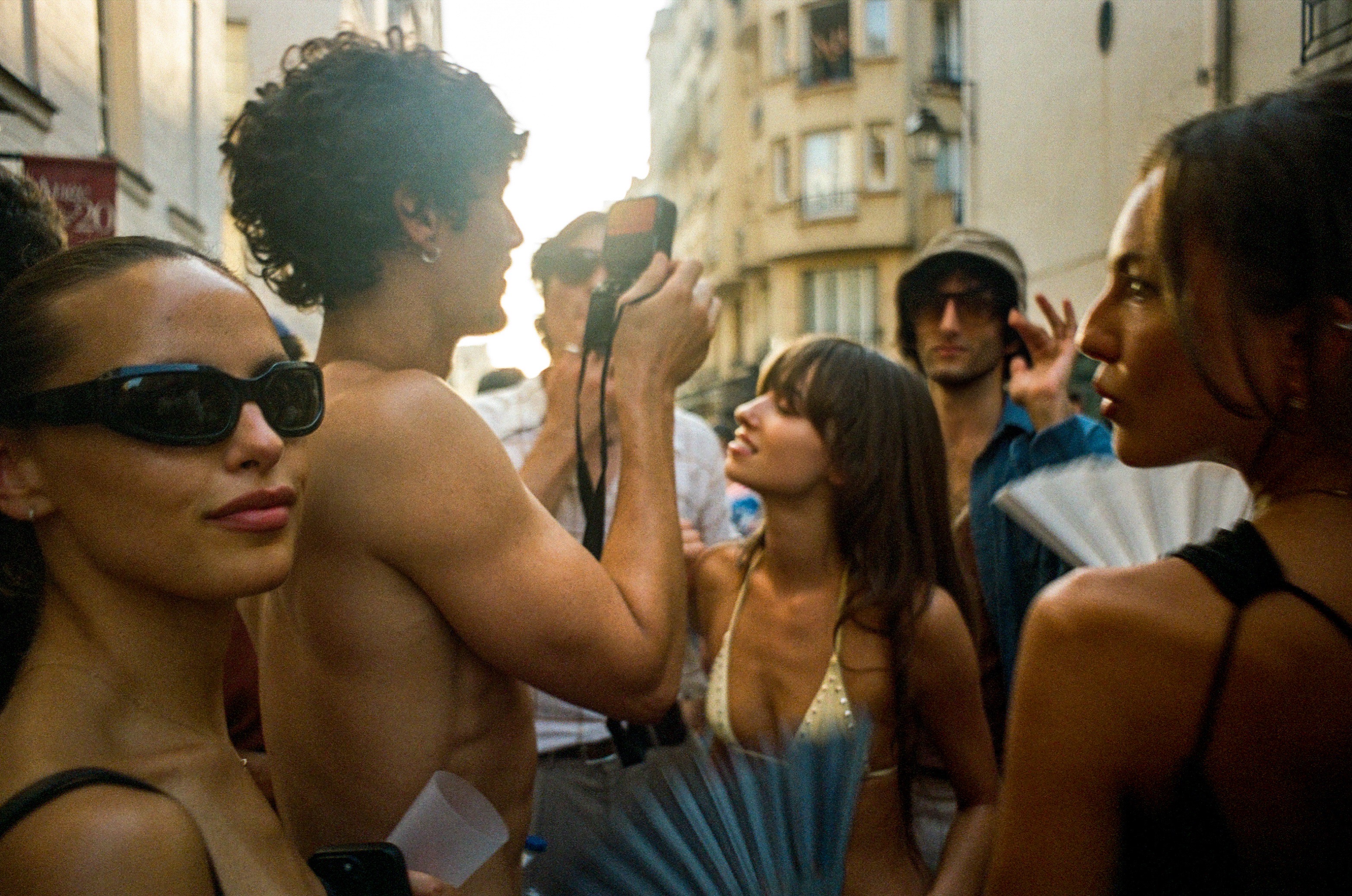 A crowded street party in warm evening light