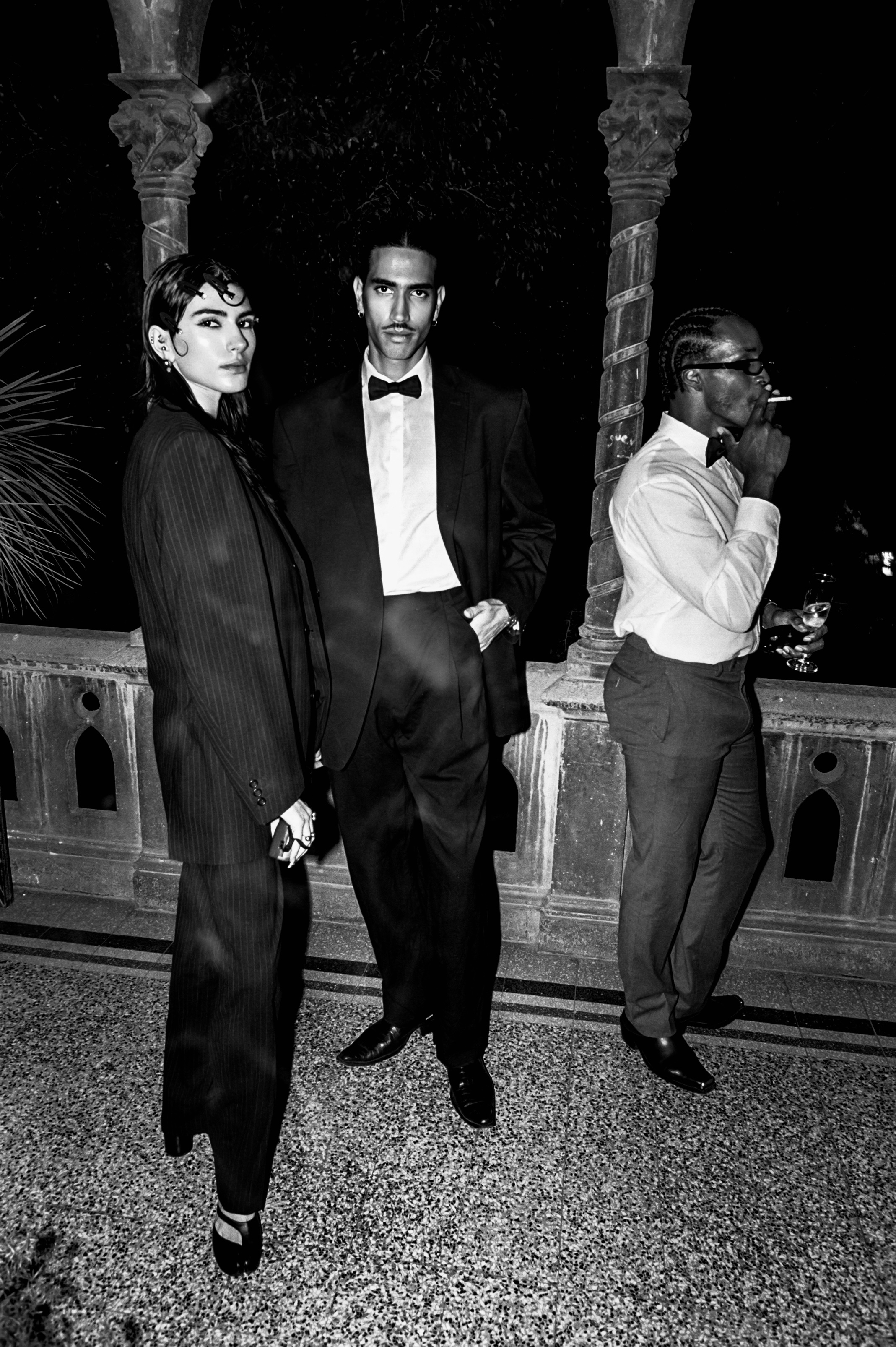 Three sharply dressed guests at a black-tie evening event